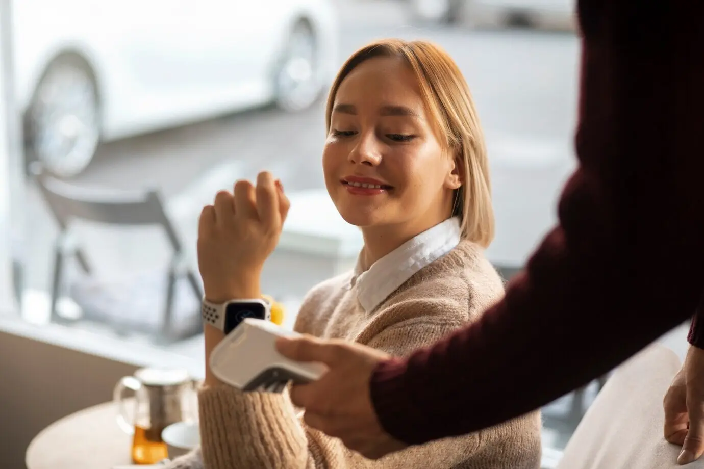 В ресторане человек оплачивает счёт с помощью технологии NFC.